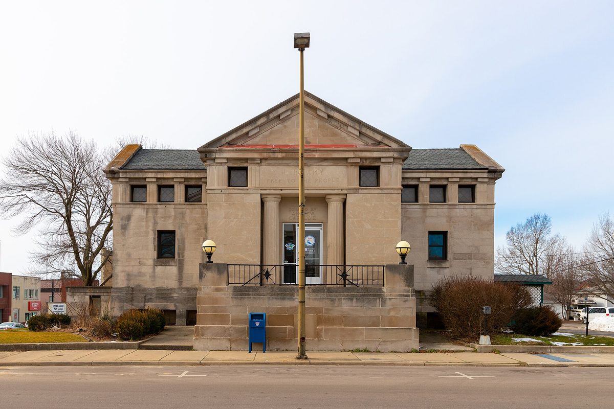 The former Carnegie Library at 321 E. Main in Niles, a gray stone building with columns and a pediment, with a blue mailbox in front