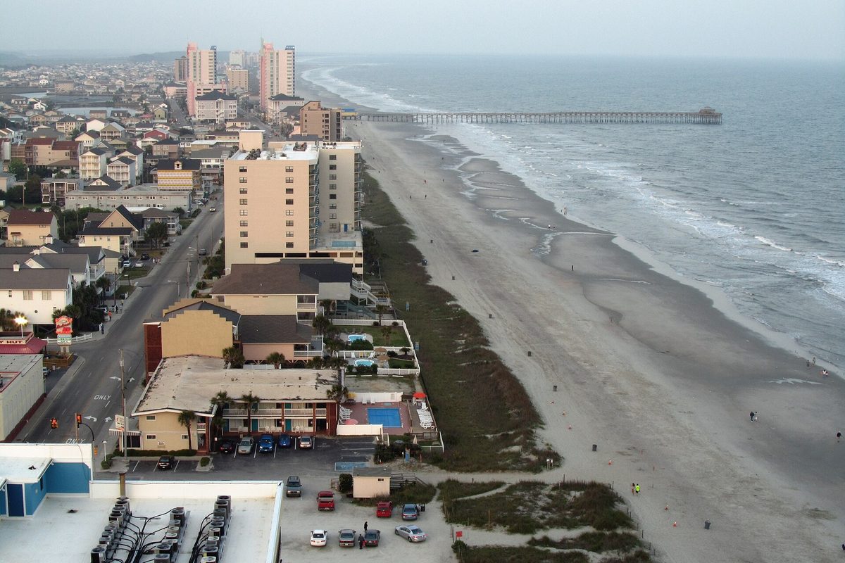 Aerial view of North Myrtle Beach, with hotels and beach houses along the sand and Cherry Grove Pier reaching into the Atlantic