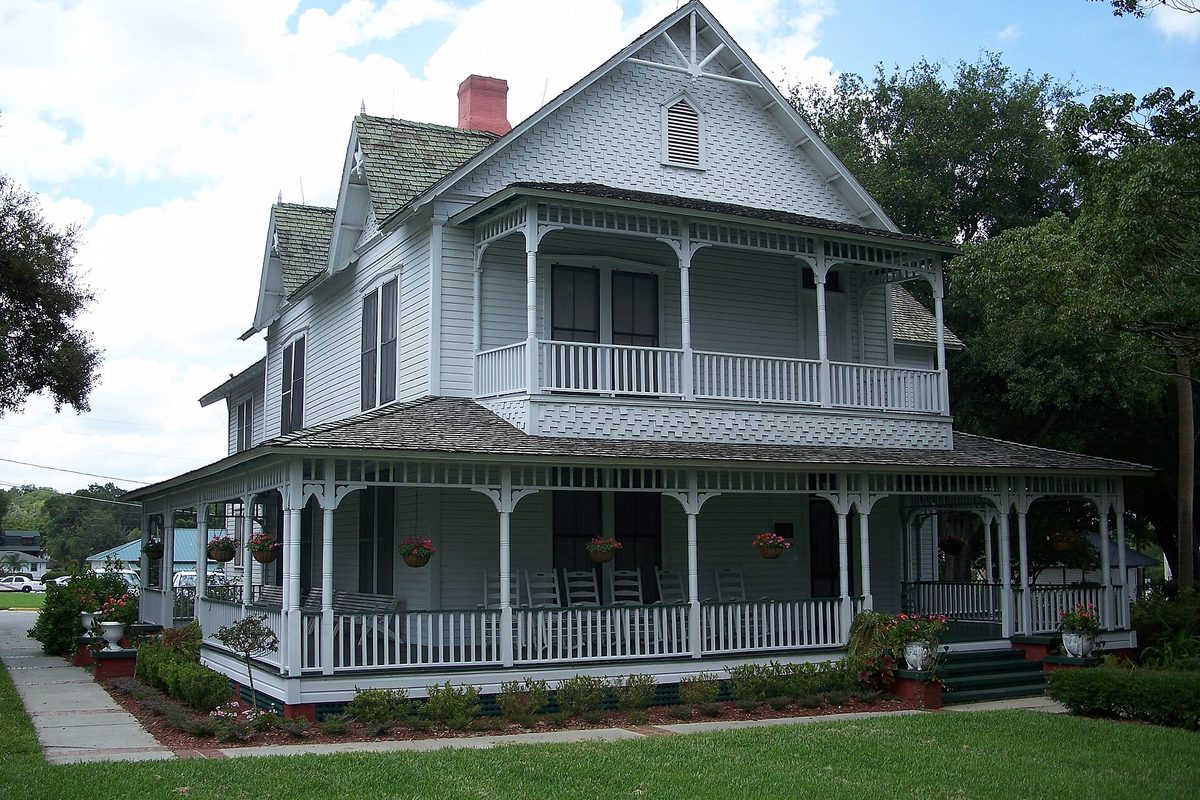 The two-story white Withers-Maguire House in Ocoee, with wraparound porches, hanging flower baskets and a red brick chimney