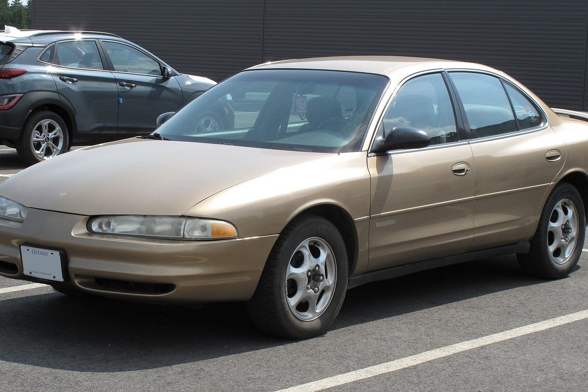 A light gold 1998 Oldsmobile Intrigue sedan in a parking lot, seen from the front left