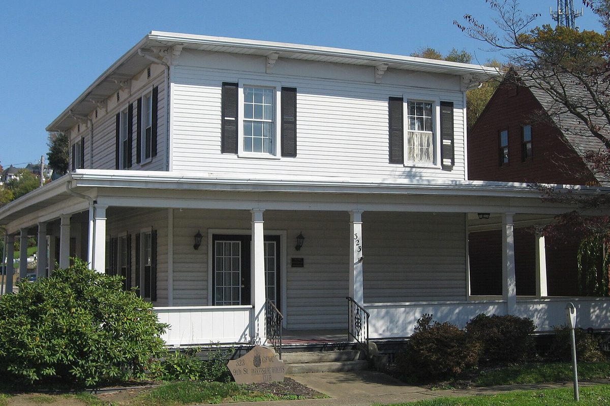 The Parkersburg Women's Club on Ninth Street, a white two-story clapboard house from 1860 with black shutters and a wide front porch