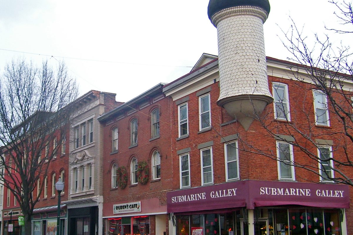 Red brick storefronts at Division and Park streets in downtown Peekskill, with a tall tiled Moorish Revival tower rising from the corner building