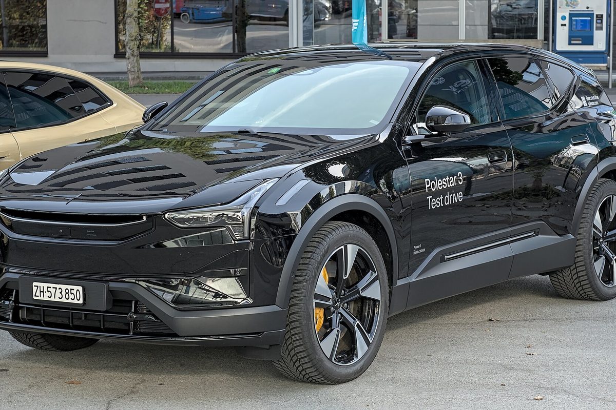 A black Polestar 3 SUV with test-drive lettering on its front door, parked outside a glass storefront