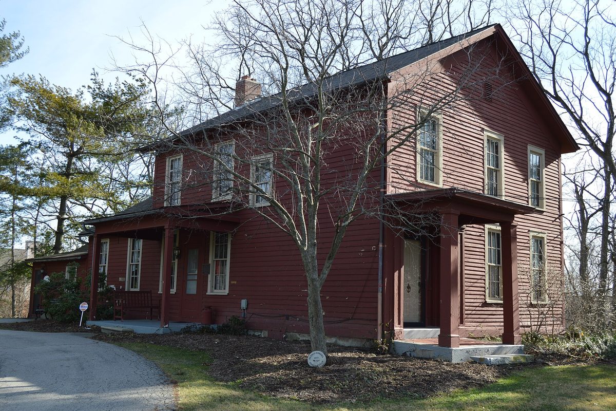 The Alexander W. Livingston House in Reynoldsburg, a two-story red clapboard house with a covered front porch, among bare trees