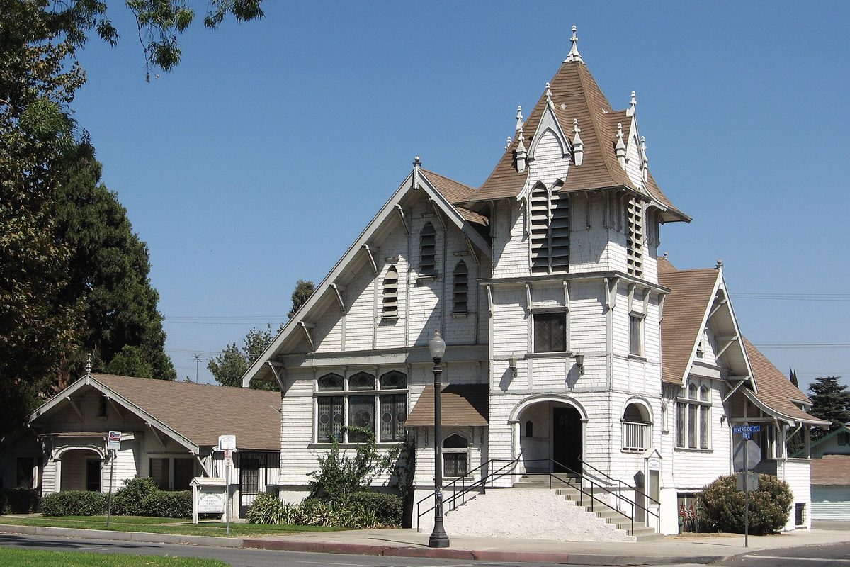 The white 1907 First Christian Church in Rialto, a wooden Victorian building with a tall shingled steeple, now home to the Rialto Historical Society