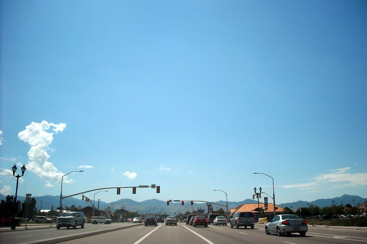 12600 South westbound in Riverton, a wide road with traffic lights at the Redwood Road intersection and mountains on the horizon