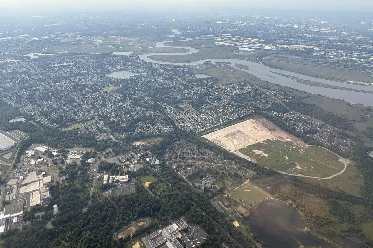 Aerial view of western Sayreville's neighborhoods and woods, with the Raritan River winding across the top of the frame