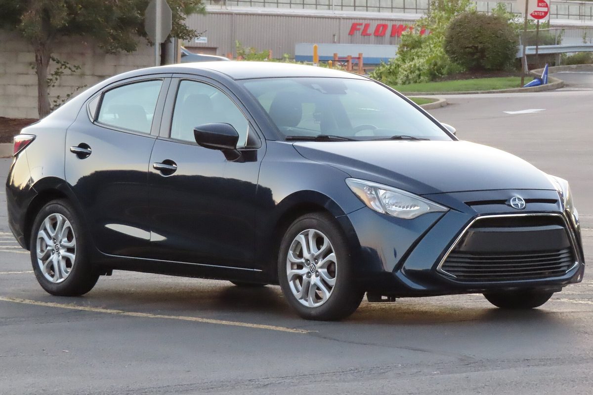 A dark blue 2016 Scion iA sedan seen from the front right, parked in an empty lot