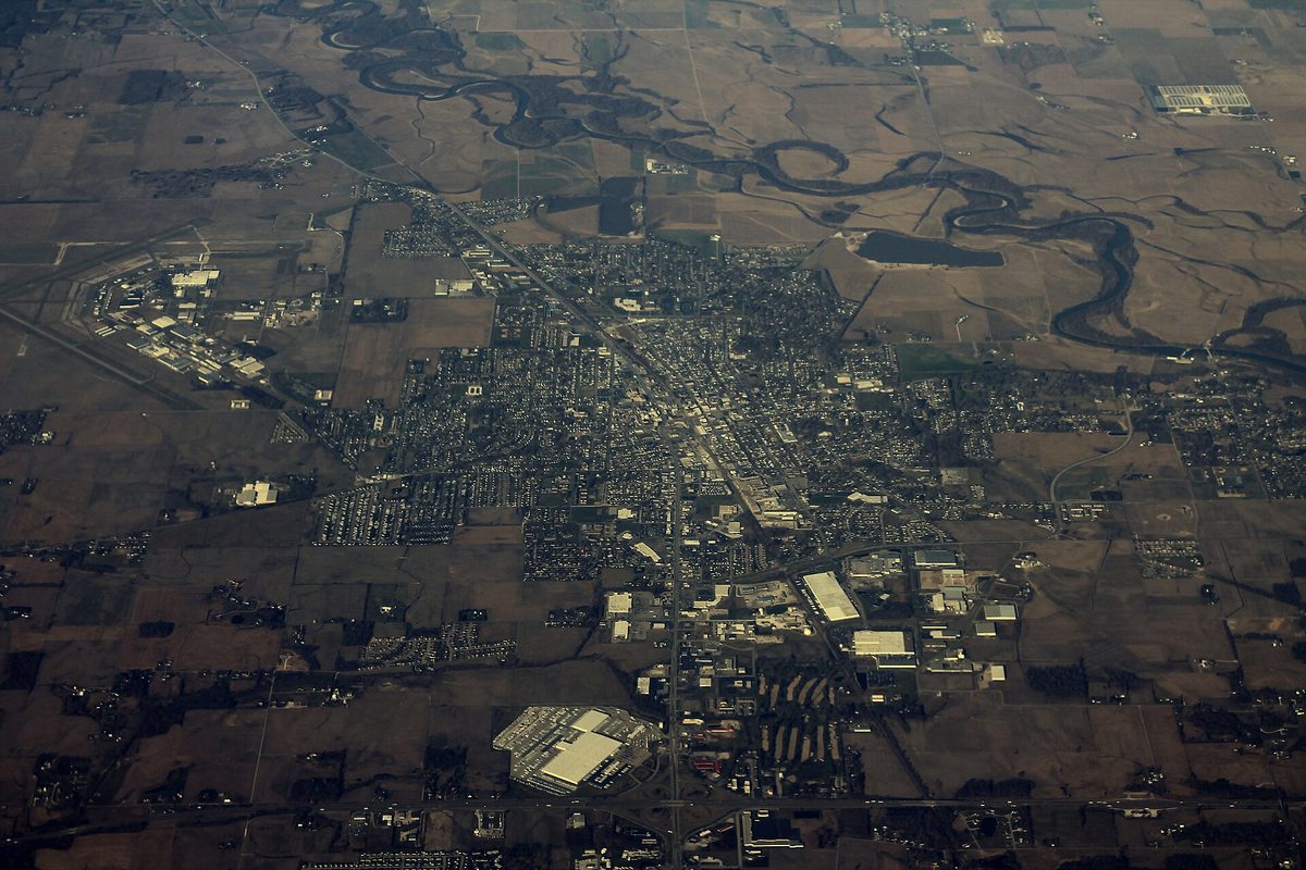 Aerial view of Seymour, its streets and industrial buildings spread across flat brown farmland with a winding river to the north