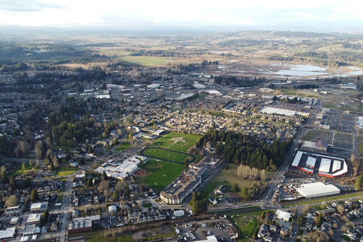 Aerial view of Sherwood with sports fields, a school, neighborhoods and farmland stretching to the horizon