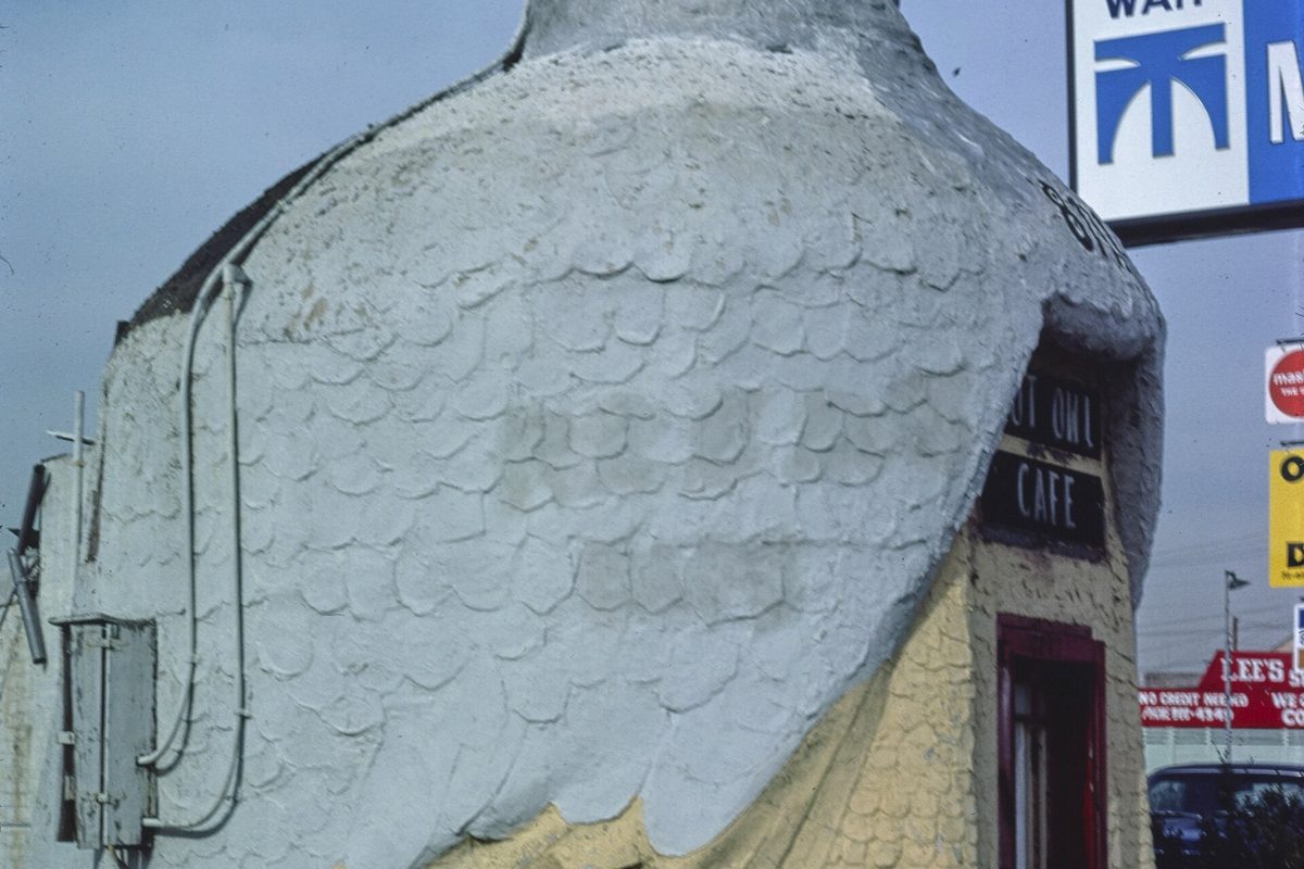 Close view of the old Hoot Owl Cafe in South Gate, a building shaped like a giant white owl with the cafe name over its red doorway