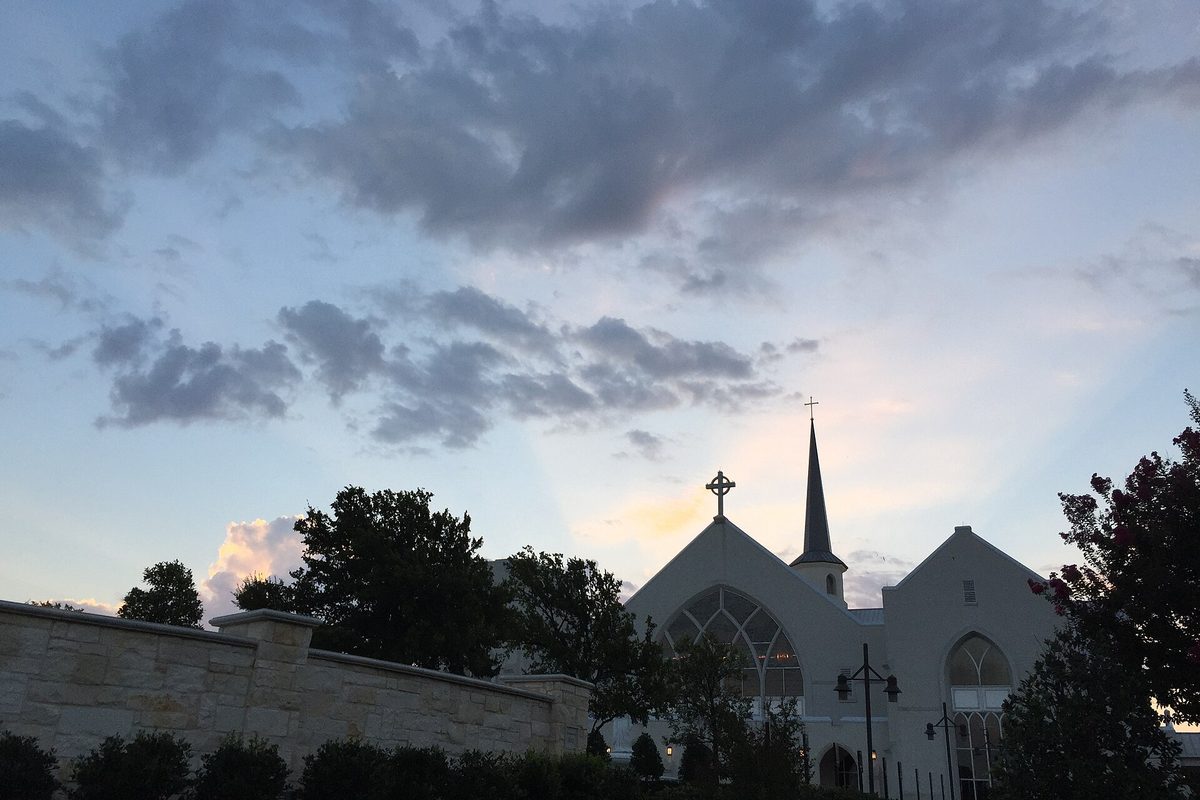 White's Chapel Methodist Church in Southlake, its steeple dark against a cloudy evening sky