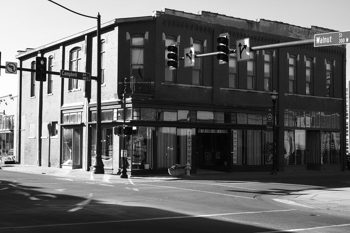 Black-and-white photo of a two-story brick commercial building at the corner of Walnut and Campbell in downtown Springfield, with traffic signals and street signs overhead
