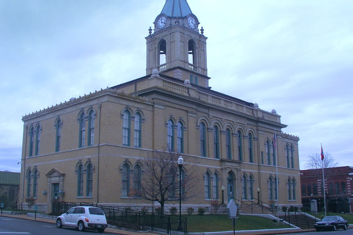 The Robertson County Courthouse in Springfield, a tan two-story building with arched windows and a clock tower, under a gray sky
