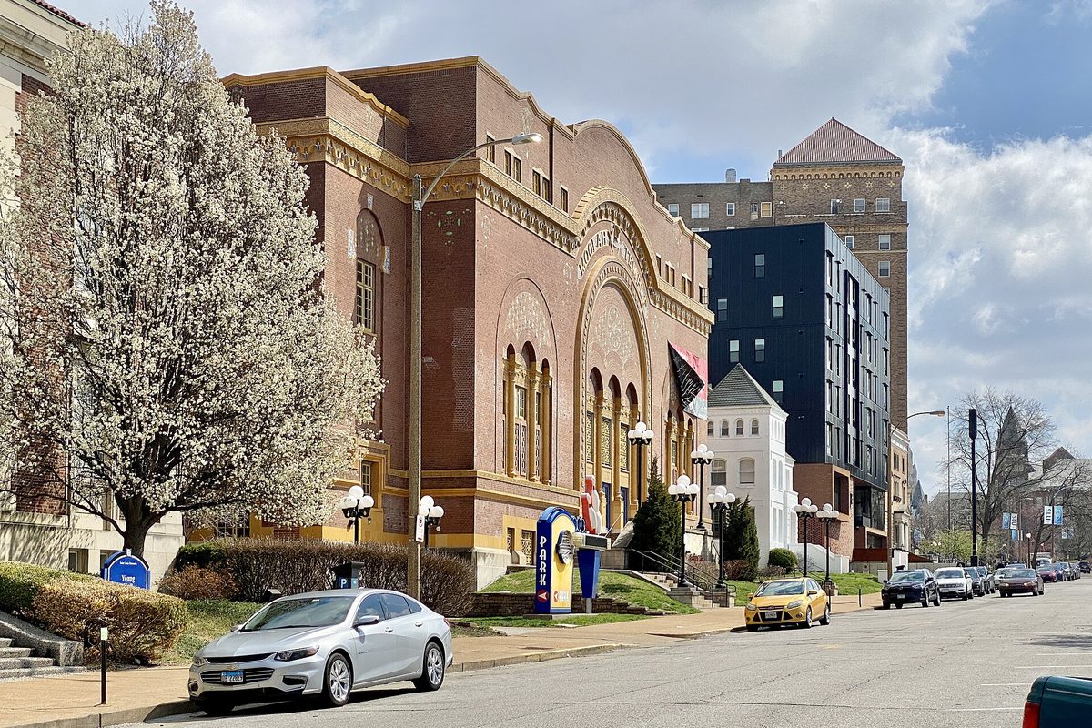 The Moorish Revival Moolah Temple building on McPherson Avenue in Grand Center, with a white flowering tree and cars parked along the street