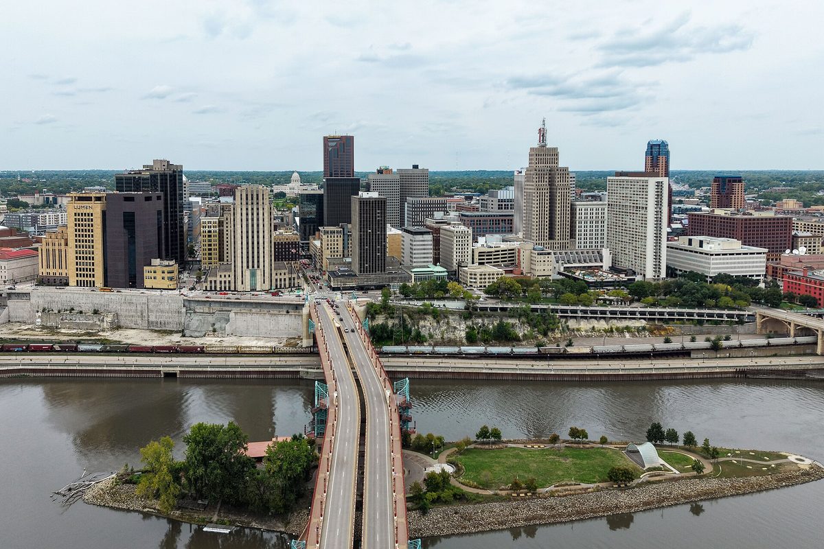 Aerial view of downtown St. Paul above the Mississippi River, with a bridge crossing to a small green island park