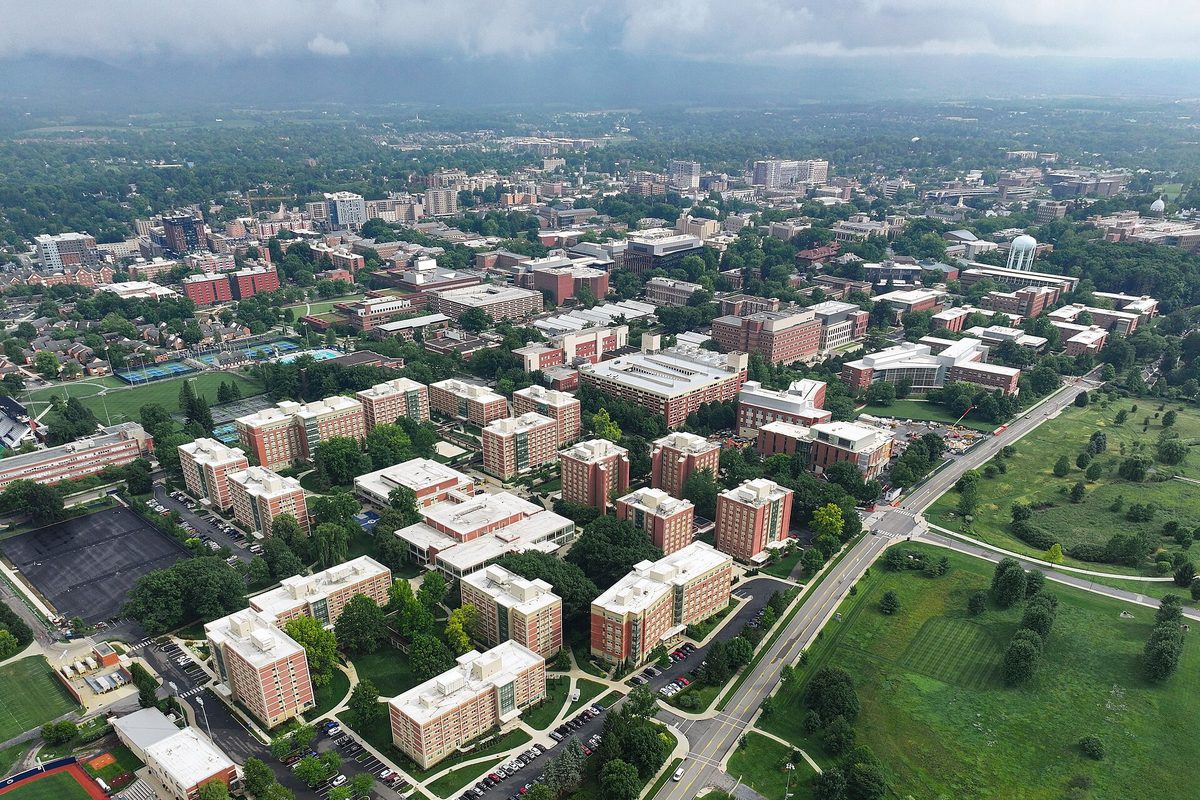 Aerial view of State College and Penn State's University Park campus, rows of brick residence halls among trees under a gray sky