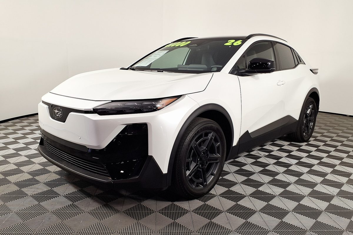 A white 2026 Subaru Uncharted compact crossover with black lower trim and black wheels, parked on a checkered showroom floor