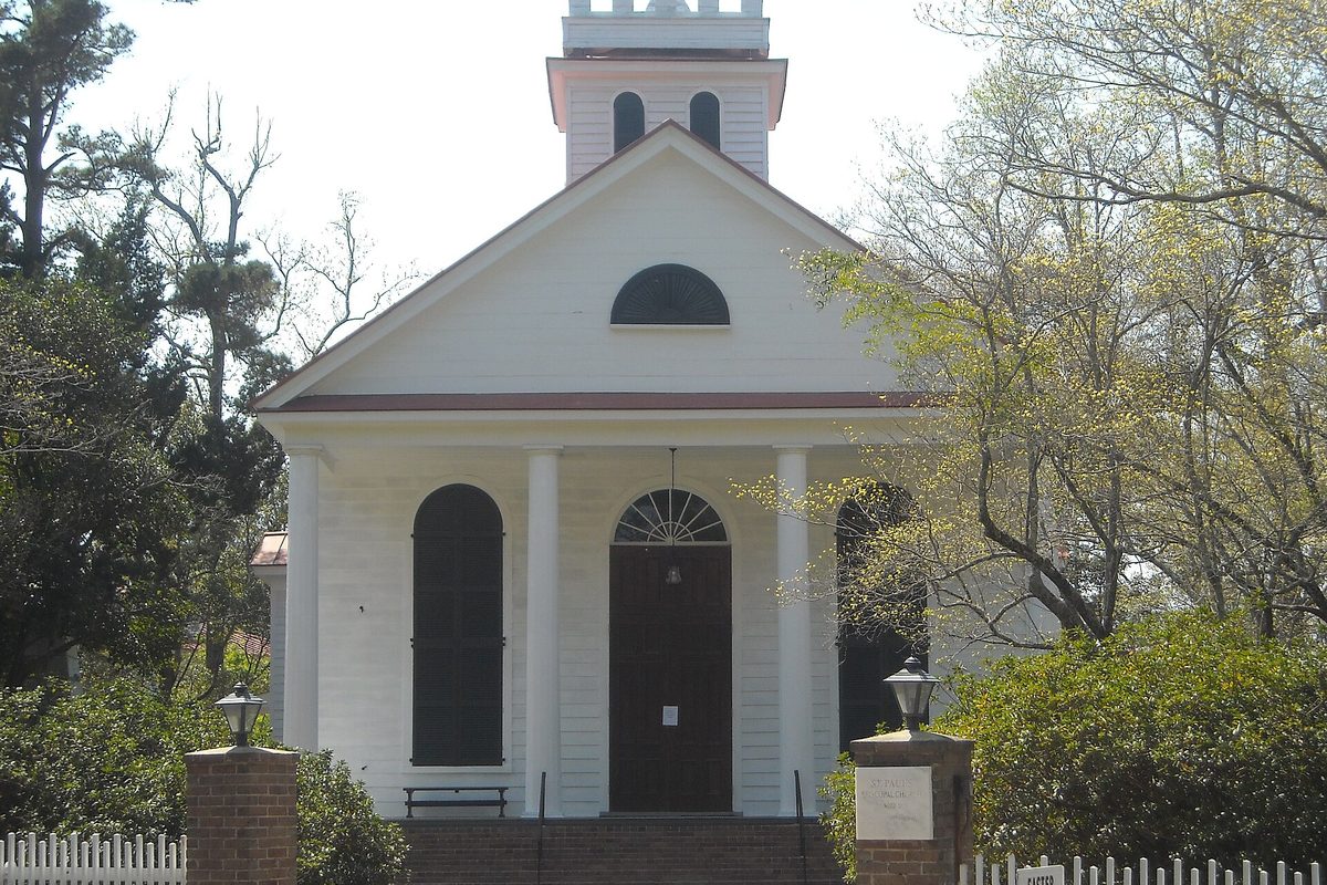 St. Paul's Episcopal Church in Summerville, a white church with columns, arched windows and a bell tower, framed by spring trees