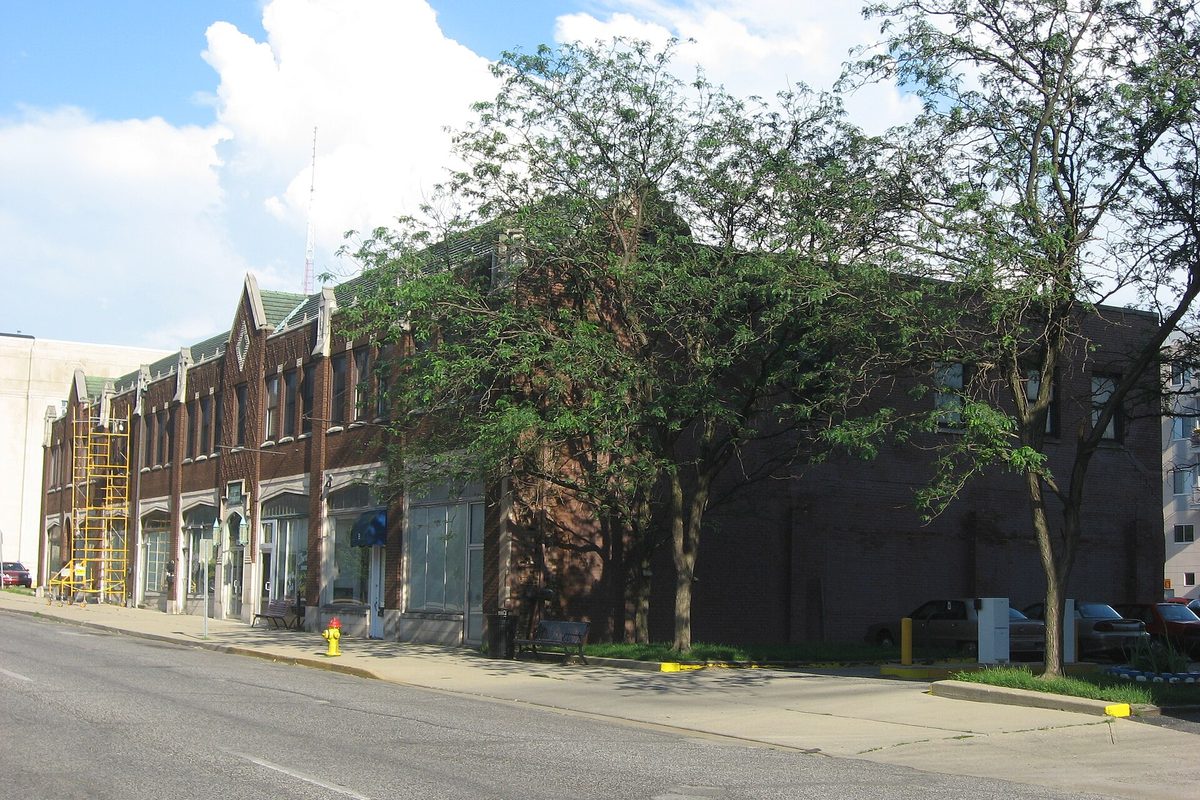 The two-story brick Chamber of Commerce Building on Cherry Street in Terre Haute, with pointed gables and leafy trees along the sidewalk on a sunny day