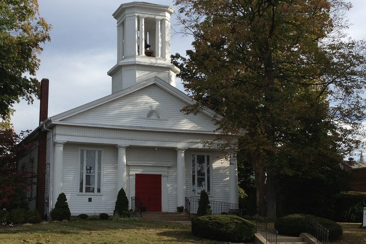 St. Mark in Wadsworth, a white church with a columned front, a red door and an open bell cupola, beside trees turning color