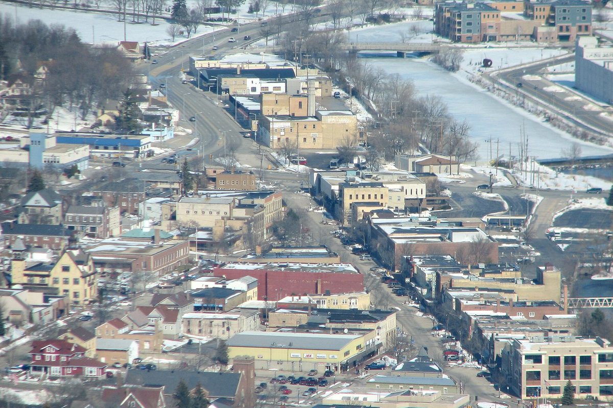 Aerial view of downtown West Bend in winter, with snow on the roofs and the river running along the right side of the town