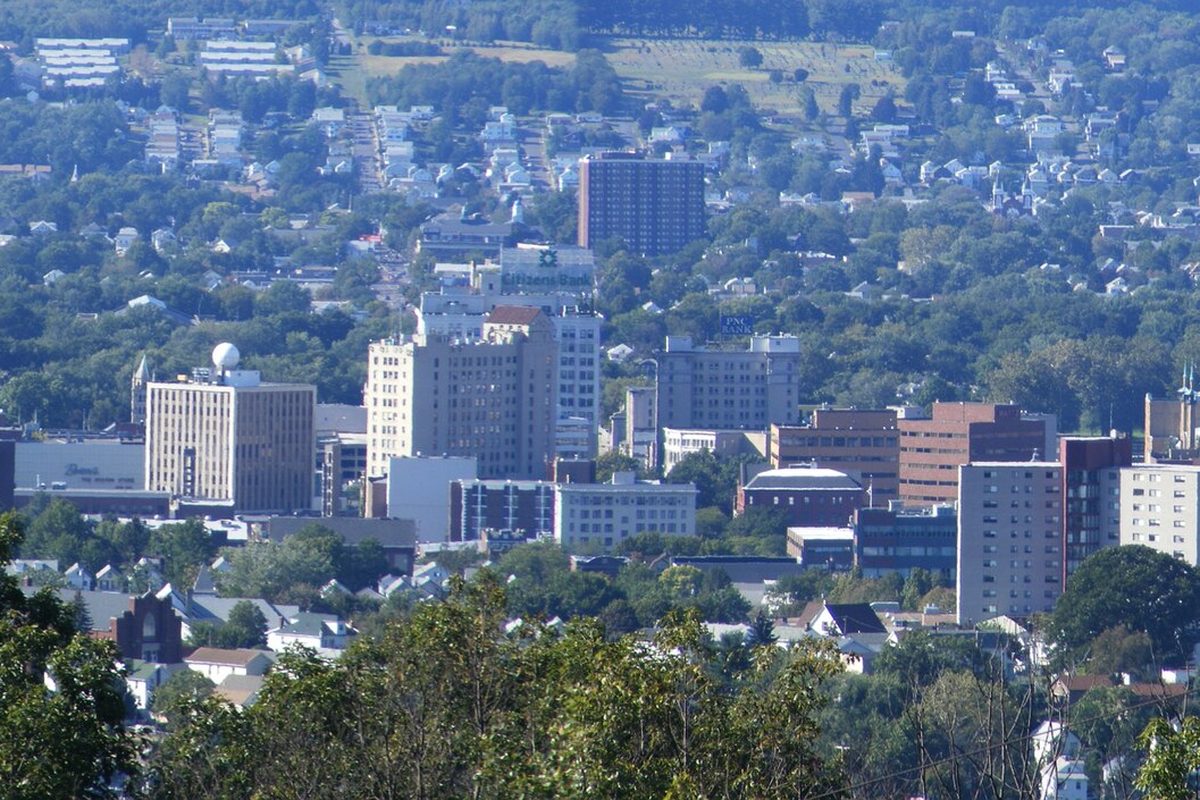 Downtown Wilkes-Barre seen from Laurel Run, office towers in the middle with tree-covered hills and houses behind them