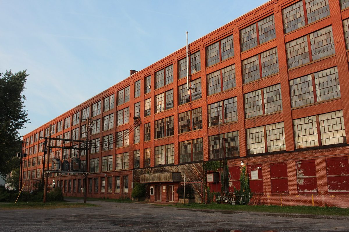 The Lycoming Rubber Company building, known as the Pajama Factory, a long four-story red brick factory with rows of tall windows in evening light