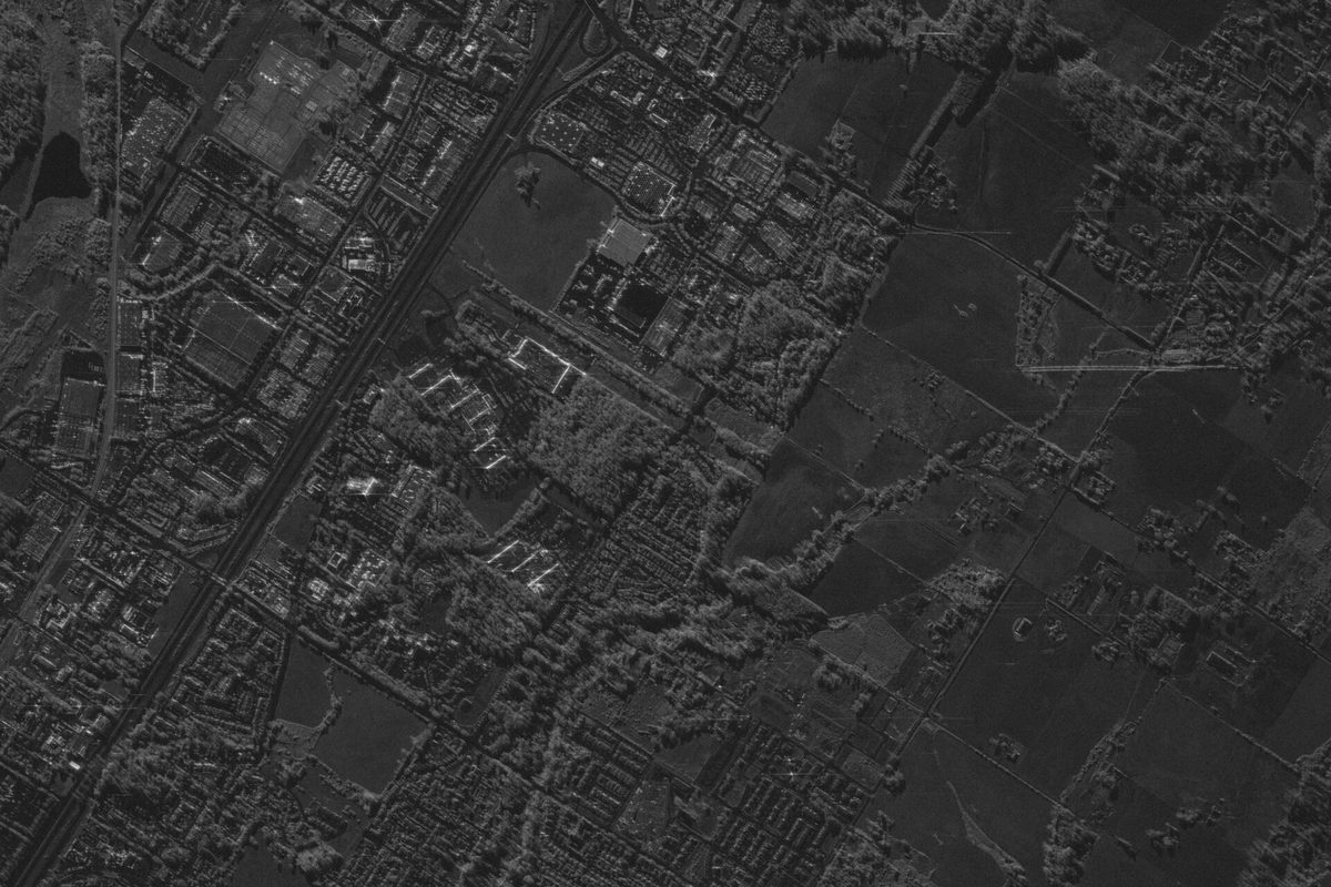 Grayscale satellite radar image of Wilsonville, with dense streets and buildings on one side of a diagonal highway and open fields on the other