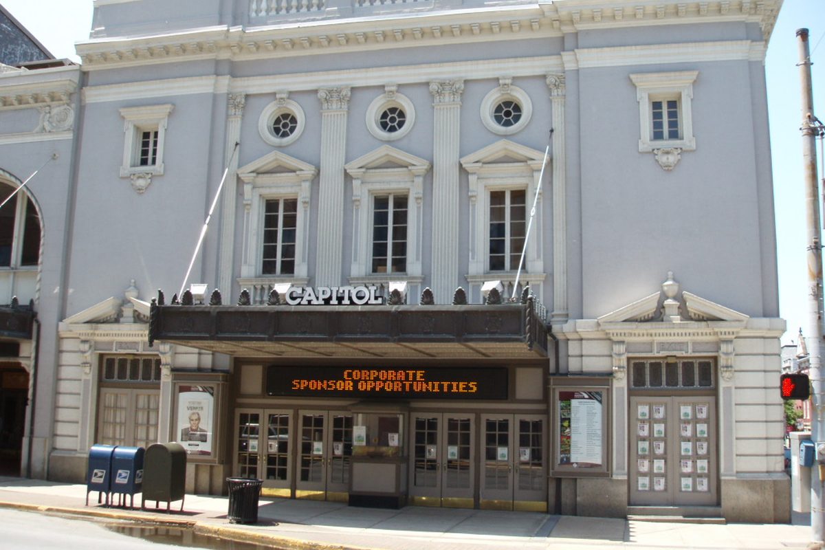 The pale gray Capitol theater front of York's Strand-Capitol Performing Arts Center, with its marquee over glass doors and blue mailboxes at the curb